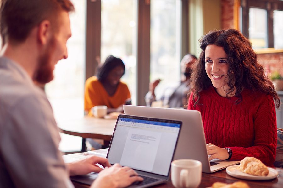 business-couple-with-laptops-having-informal-meeti-J9QDN9M